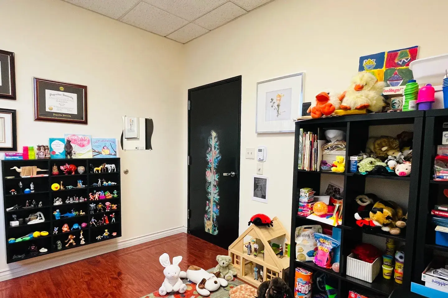 A room with toys and books on the floor.