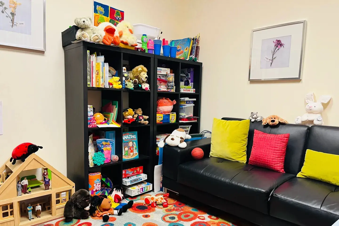 A black couch and some books on the floor